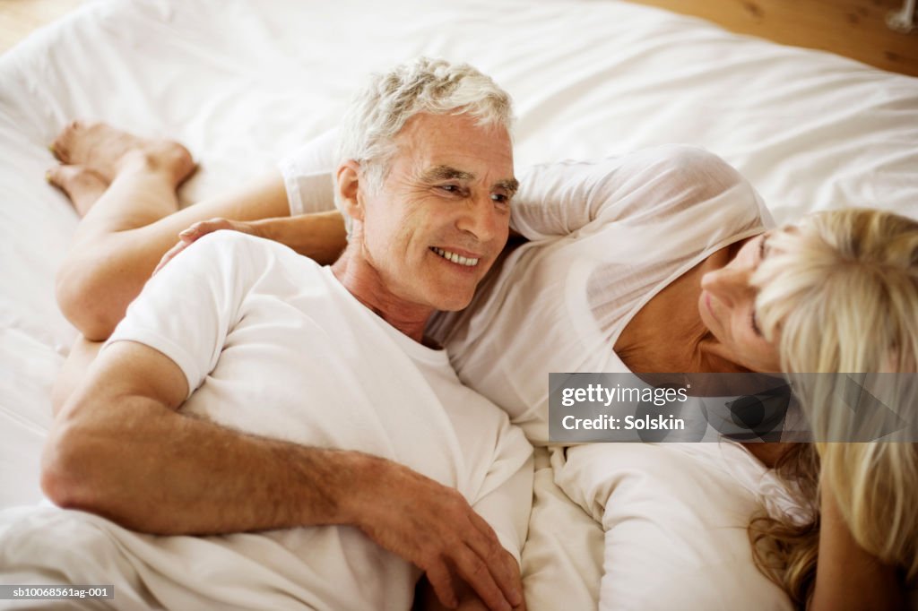 Mature couple lying on bed