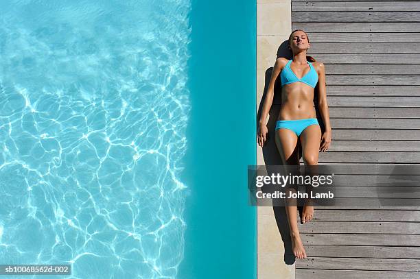 young woman sunbathing on at poolside, view from above - swimwear stockfoto's en -beelden