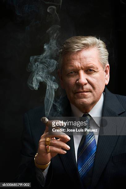 businessman smoking cigar, portrait, close-up - cigar photos et images de collection