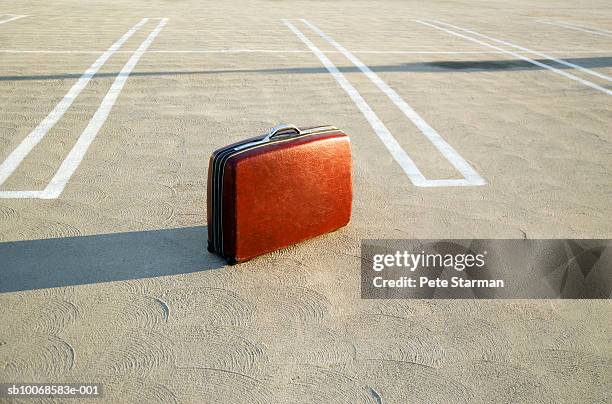 suitcase on empty parking lot - forgot something stockfoto's en -beelden