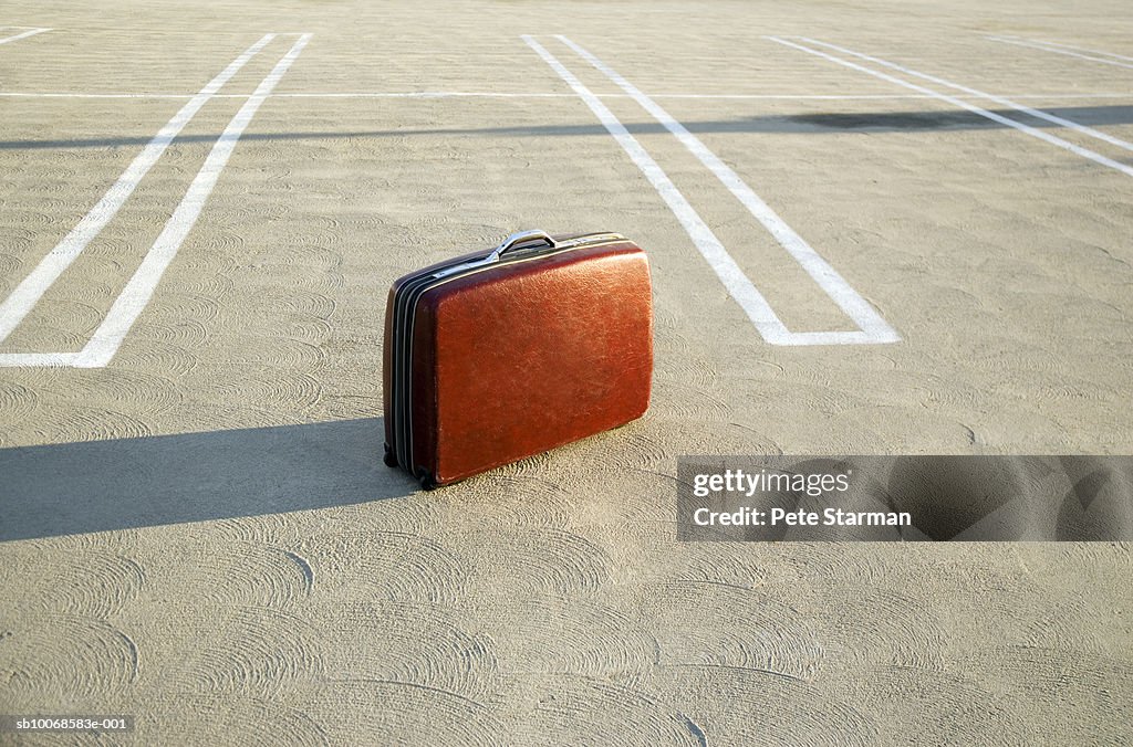 Suitcase on empty parking lot