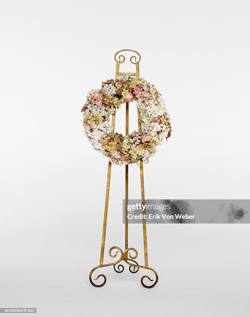 Flower wreath on stand on white background