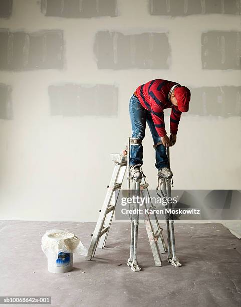 worker wearing stilts - stilts stock pictures, royalty-free photos & images