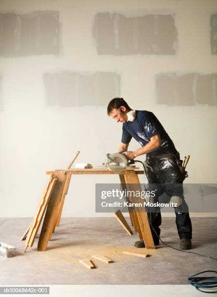 man using electric saw to cut wood - wood worker posing ストックフォトと画像