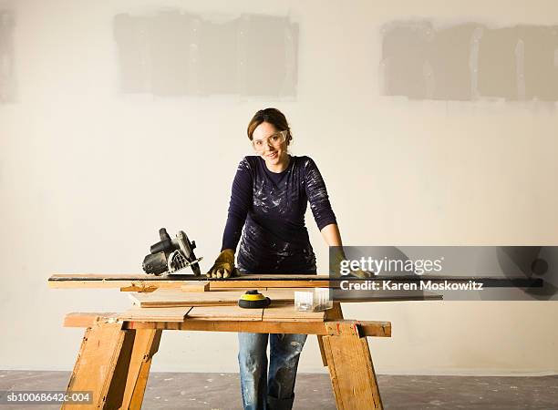 woman doing woodwork, smiling, portrait - serra-circular imagens e fotografias de stock