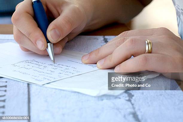 woman writing letter, close-up - korrespondenz stock-fotos und bilder