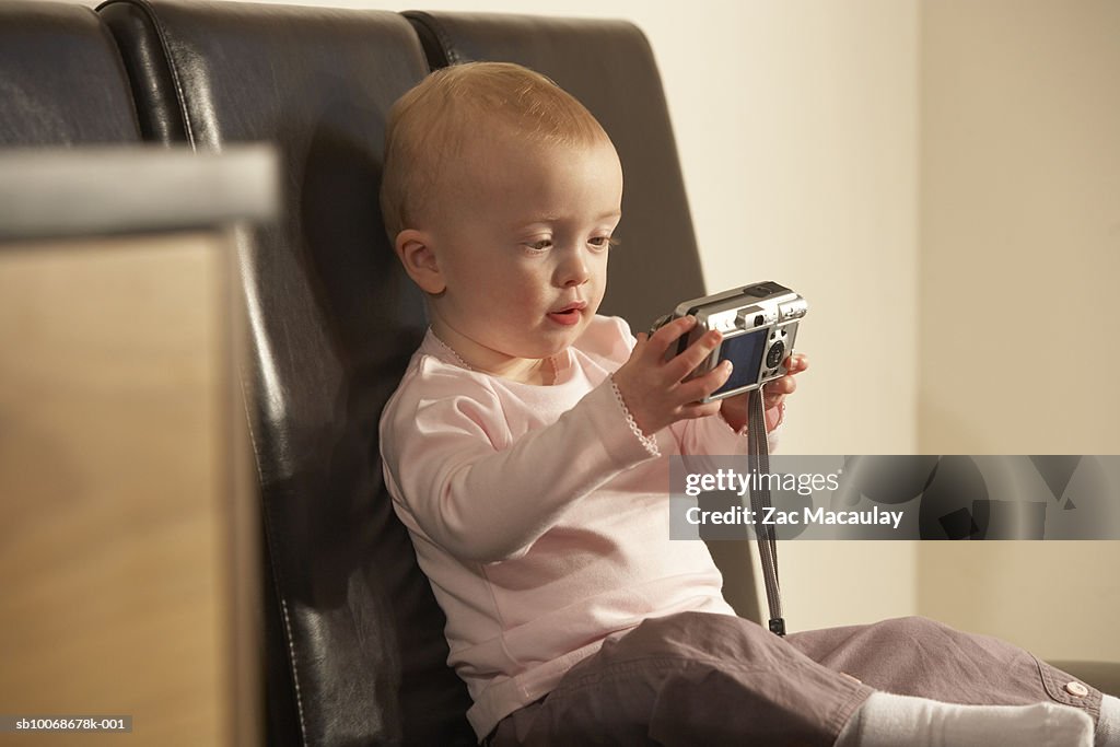 Baby Using Camera Baby Girl Holding Digital Camera Sitting On Chair High-Res Stock Photo ...