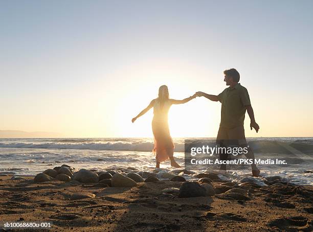 couple on beach holding hands at dusk - puerto vallarta stockfoto's en -beelden