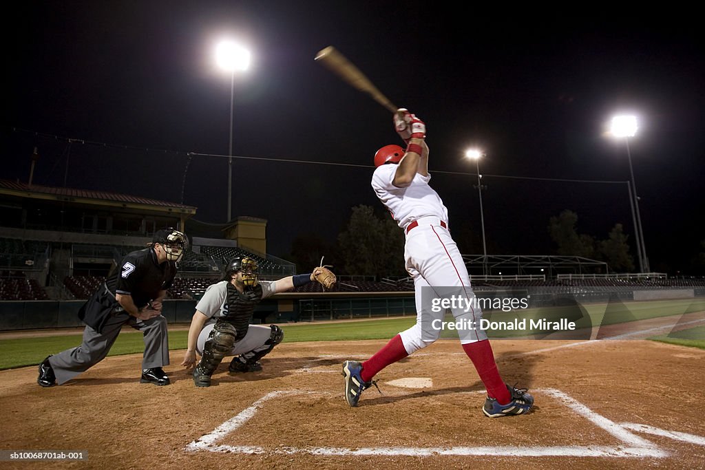 USA, California, San Bernardino, baseball players with batter swinging