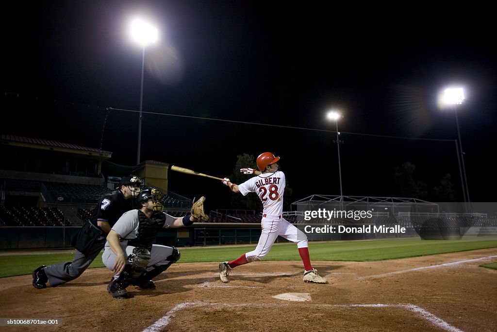 USA, California, San Bernardino, baseball players with batter swinging