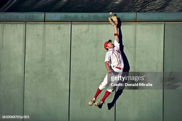 usa, california, san bernardino, baseball player making leaping catch at wall - baseball sport stock pictures, royalty-free photos & images
