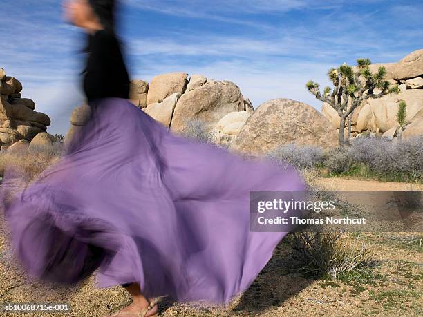 woman dancing in desert, blurred motion - purple dress stockfoto's en -beelden
