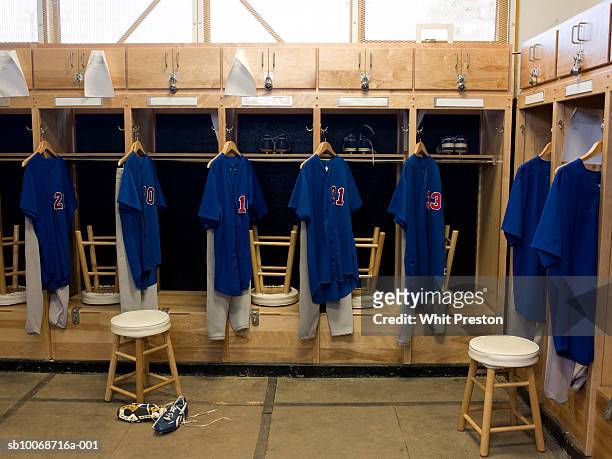 team jerseys hanging in locker room - divisa sportiva foto e immagini stock