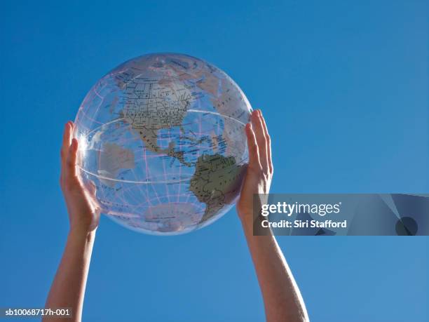 woman holding transparent globe, low angle view - globo terrestre foto e immagini stock