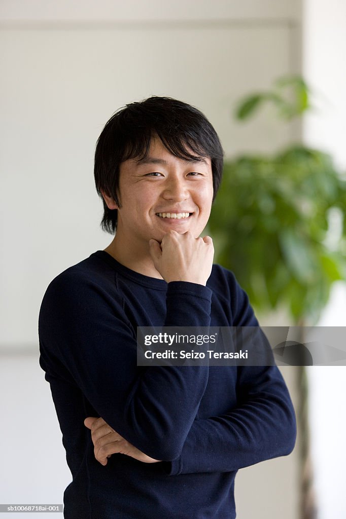 Man with hand on chin, smiling, portrait