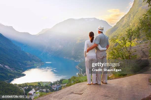 couple standing on rock overlooking valley and river - love on the rocks stock pictures, royalty-free photos & images