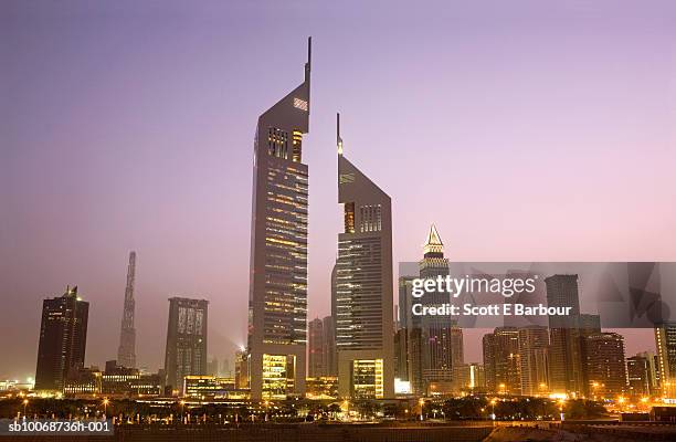 united arab emirates, dubai, sheikh zayed road at dusk - emirates towers stockfoto's en -beelden
