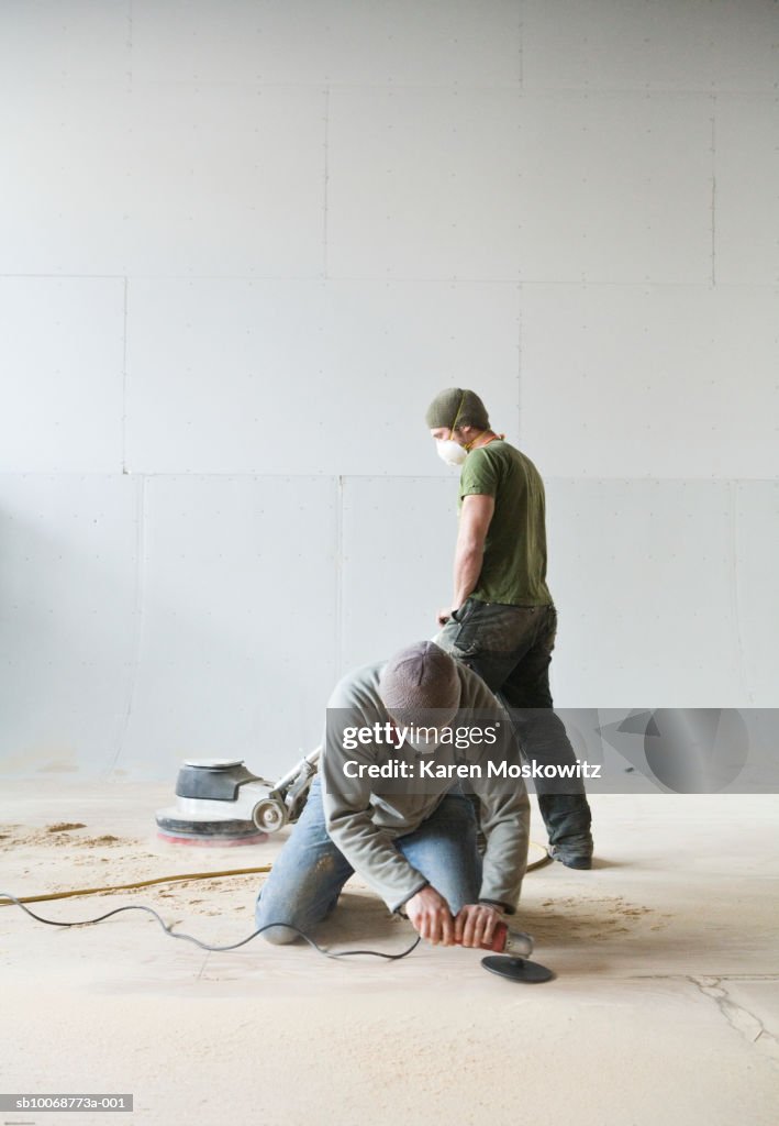 Two men sanding floor