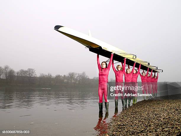 female rowers carrying eight person-scull - rennrudern stock-fotos und bilder