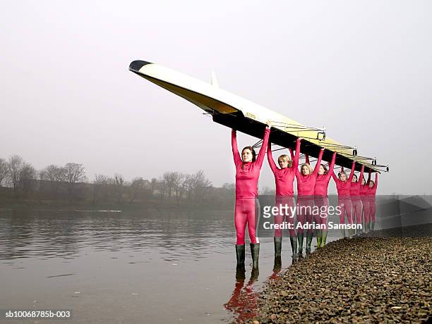 female rowers carrying eight person-scull - teamwork rowing stock pictures, royalty-free photos & images