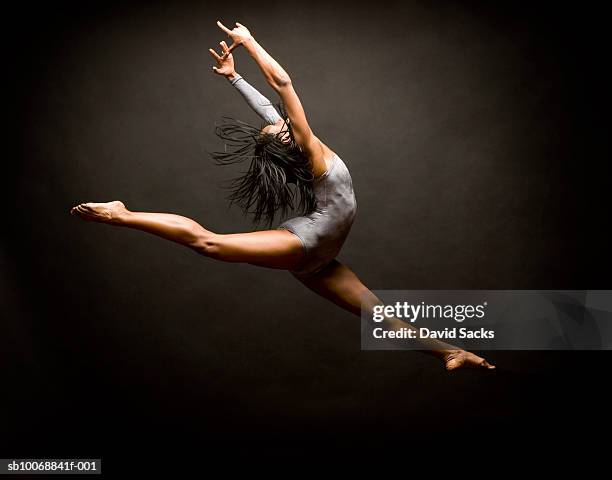 female ballet dancer leaping in air - actuación conceptos fotografías e imágenes de stock