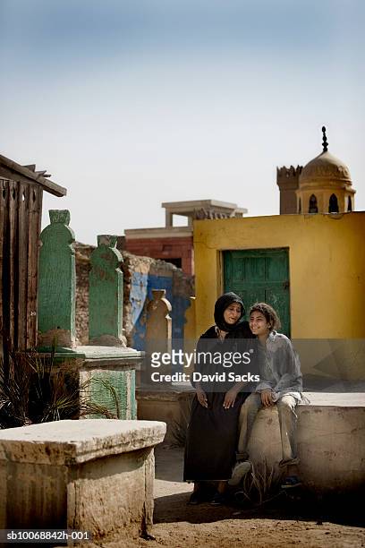 grandmother and granddaughter (12-13) sitting side by side on graves - egyptian family stock pictures, royalty-free photos & images