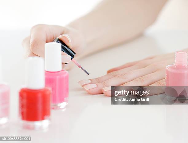 woman painting nails, close-up - lackierte-fingernägel-finger stock-fotos und bilder