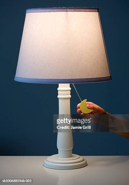 child's hand holding switch of lamp - electric lamp stock pictures, royalty-free photos & images