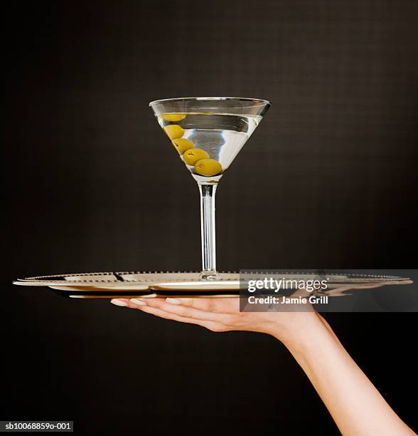 woman's hand holding martini on tray, close-up - martini glass stock pictures, royalty-free photos & images