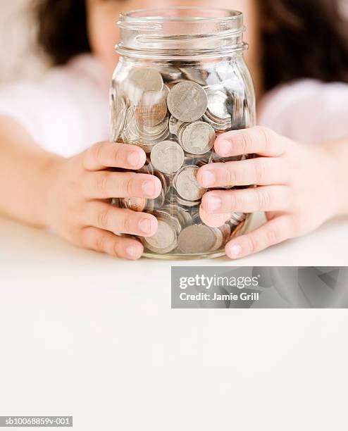 child holding jar of coins, close-up, mid section - kid middle finger stock-fotos und bilder