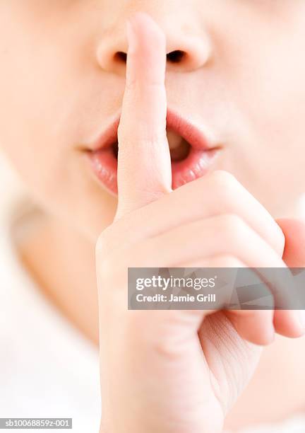 girl (6-7) with finger on lips, close-up - middle finger stock-fotos und bilder