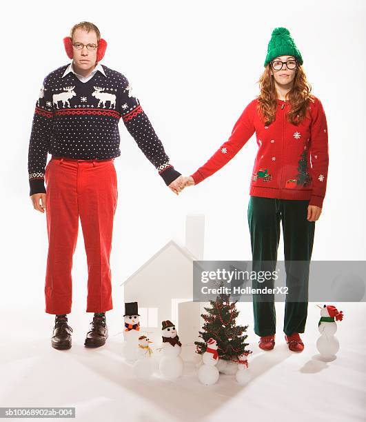 studio portrait of man and woman in holiday sweaters with christmas set - nerd sweater stock pictures, royalty-free photos & images