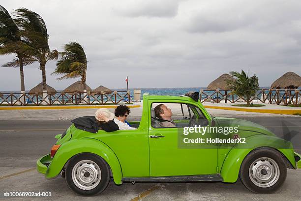 three people relaxing in convertible at seaside, side view - car sunshade stock pictures, royalty-free photos & images