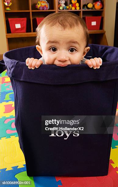 baby boy (6-11 months) sitting in toy bucket, portrait - alleen één jongensbaby stockfoto's en -beelden