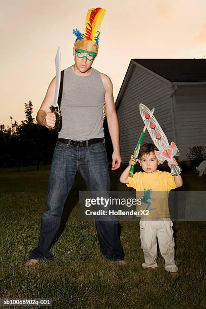 portrait of father and son (4-5) with toy swords in garden - toy sword stock pictures, royalty-free photos & images