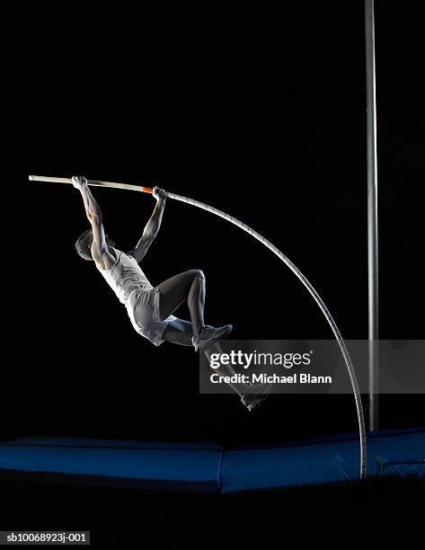 pole vault athlete jumping, side view - pole vaulter stock pictures, royalty-free photos & images