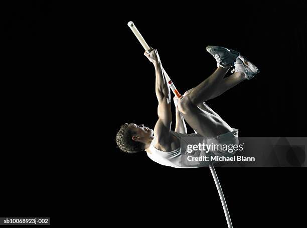 pole vault athlete jumping, side view - pole vault stock pictures, royalty-free photos & images