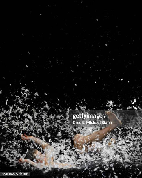 athlete falling in feather bed, side view - floating stock pictures, royalty-free photos & images