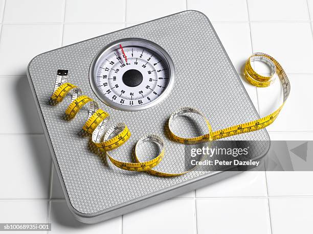 tape measure on scales, close-up - wiegen stock-fotos und bilder