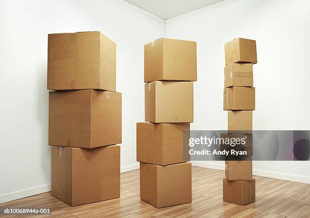 stacks of cardboard boxes in room - cardboard box stock pictures, royalty-free photos & images