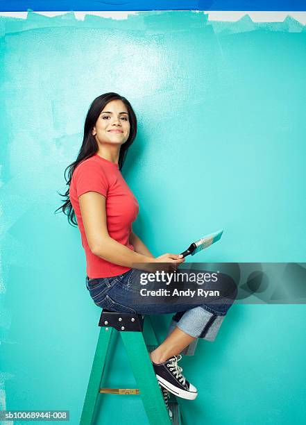 woman sitting on ladder in front of wall painted blue - diy beauty stock pictures, royalty-free photos & images