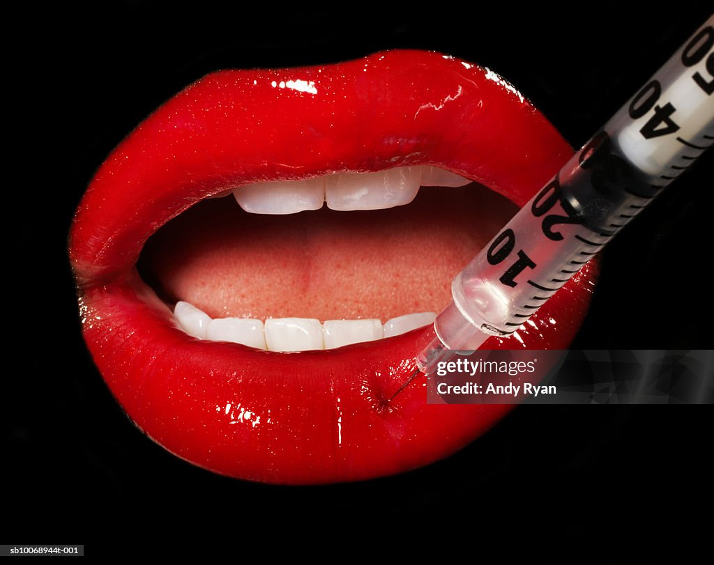 Mouth having injection, close-up, studio shot