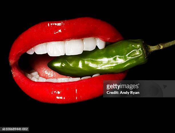 mouth biting jalepeno pepper, close-up, studio shot - female eating chili bildbanksfoton och bilder