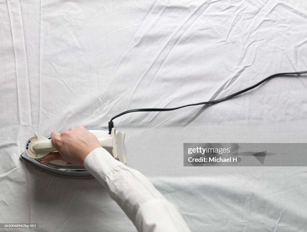 Woman ironing white cloth, close-up