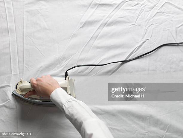 woman ironing white cloth, close-up - bügeleisen stock-fotos und bilder