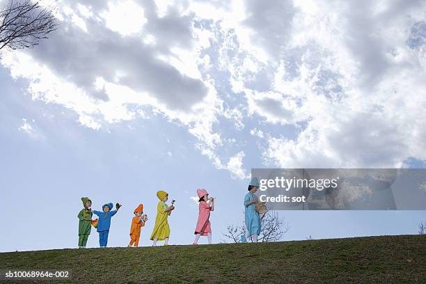 children (4-13) in colorful costume playing musical instruments in park - marching stock pictures, royalty-free photos & images