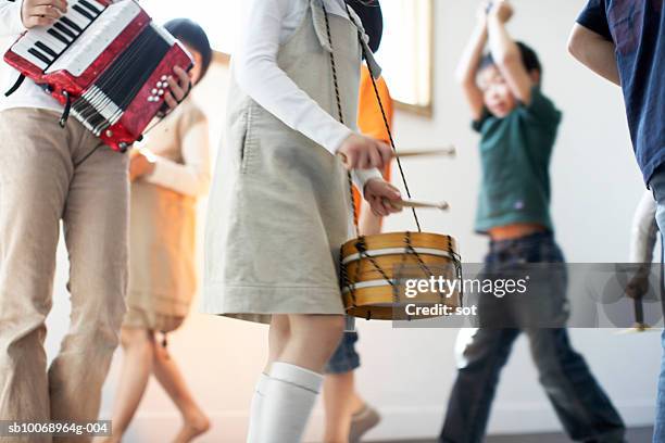 children (4-11)playing toy musical instruments, mid section - drum percussion instrument stock-fotos und bilder