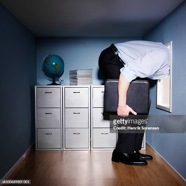 man standing in small office with head out of window, low section, side view - escaping office stock pictures, royalty-free photos & images