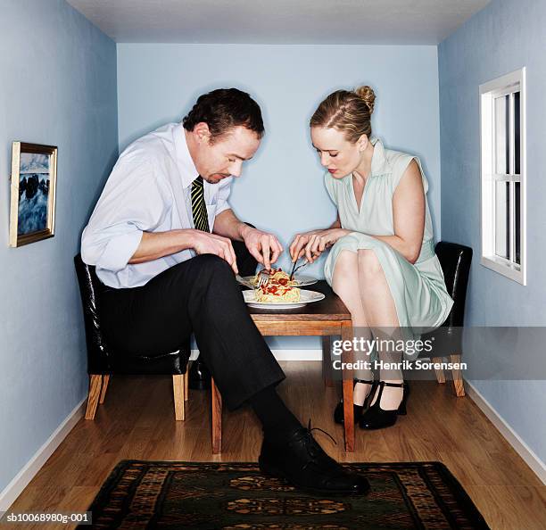 couple eating dinner in small dining room - pequeño fotografías e imágenes de stock