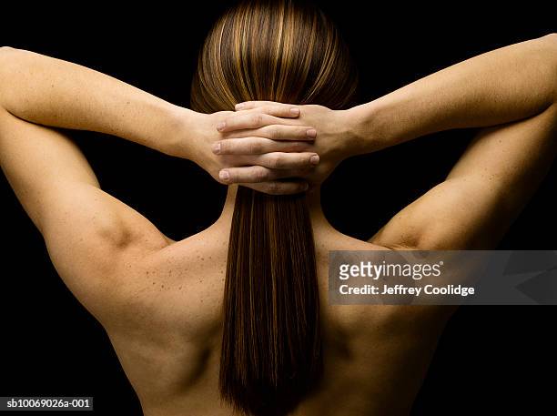 young man with hands clasped behind neck, rear view, studio shot - capelli lunghi foto e immagini stock